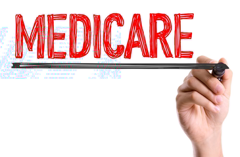 Hand with marker writing the word Medicare