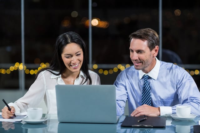 Businessman discussing with colleague over laptop in the office.jpeg