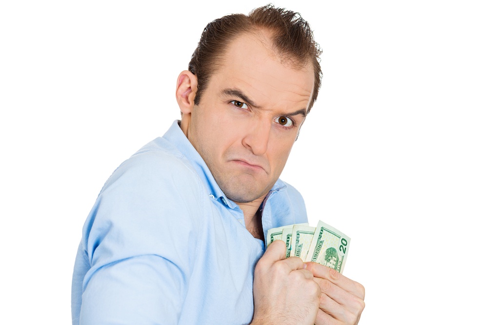 Closeup portrait of greedy banker executive CEO boss, corporate employee funny looking man, shaking holding dollar banknotes scared to loose money, suspicious isolated on white background. Expressions