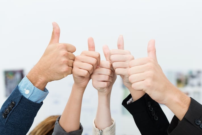 Successful diverse young business team giving a victorious thumbs up to show their success and motivation, close up view of their raised hands.jpeg